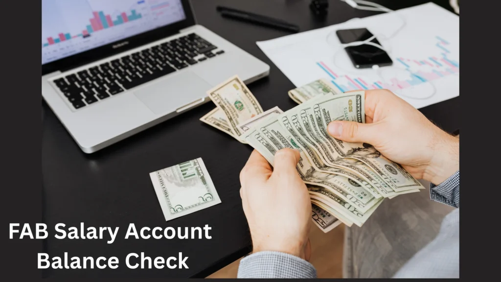 "Person counting money near laptop showing financial report for FAB Salary Account Balance Check"