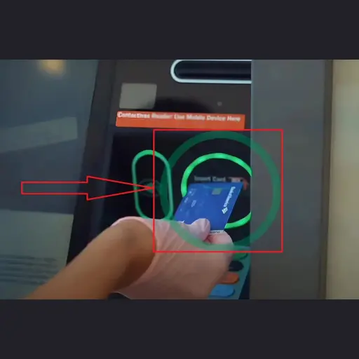 Person inserting a bank card into an ATM machine to access or activate banking services.